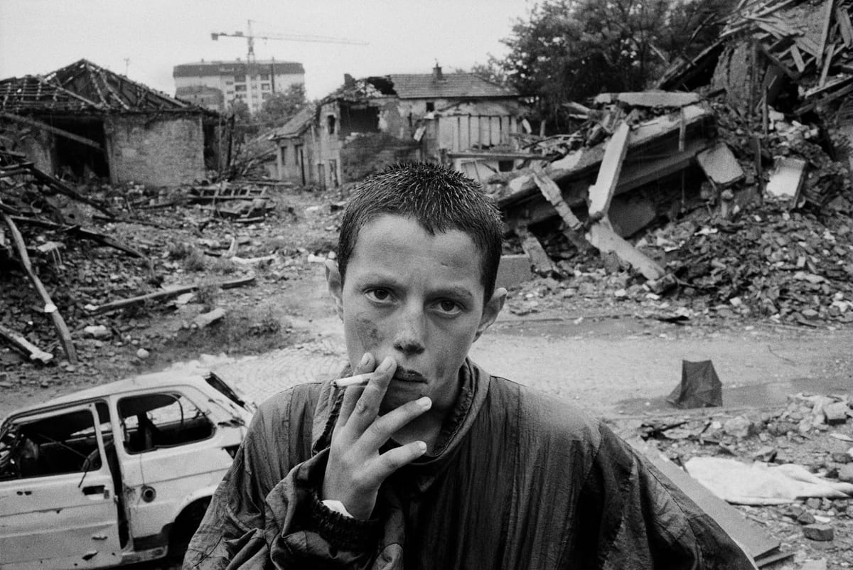 Artwork Title: KOSOVO. Pristina. A young Kosovar smokes among the ruins caused by the NATO bombing