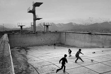 Artwork Title: Afghan boys play soccer in a war-damaged Soviet occupation-era swimming pool in Kabul
