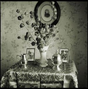 Artwork Title: Table avec des fleurs, des photographies et des coupes, à l'intérieur de la maison de Roud